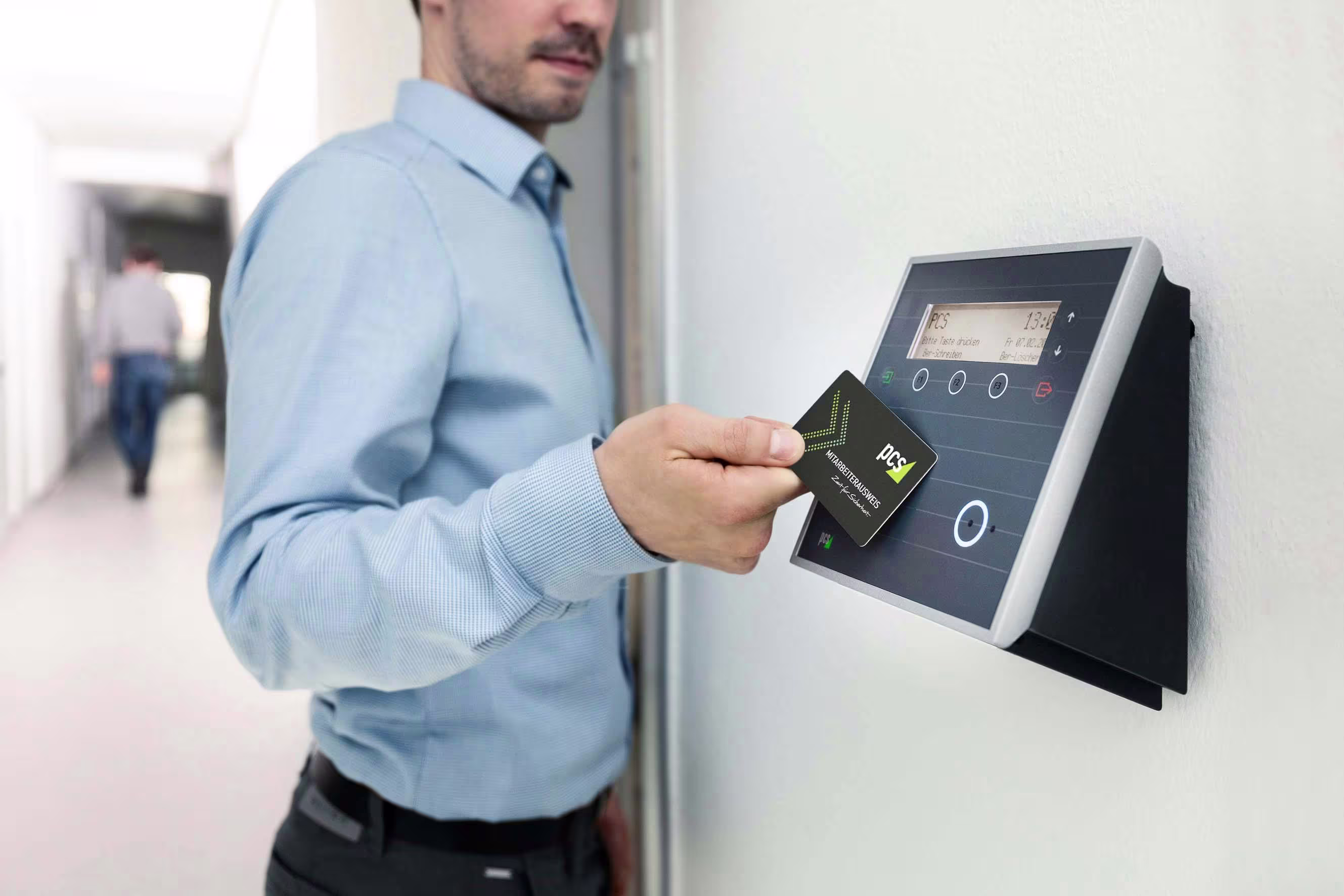 A man using RFID technology in his card to open a door with no physical contact.